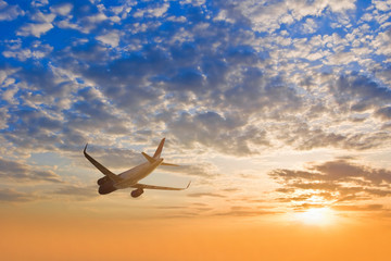 Fototapeta na wymiar airplane silhouette fly across a sky at the sunset