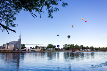 romantic couple looking Gatineau hot air balloons festival on a shore during summer came by bike