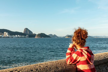 Child in a lookout looking at sugar loaf in Copacabana, Rio de Janeiro, with beach and Morro da...