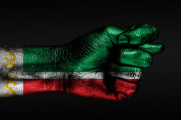 A hand with a painted Chechnya flag shows a fig, a sign of aggression, disagreement, a dispute on a...