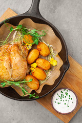 Baked tobacco chicken with potatoes, sour cream, herbs in pan
