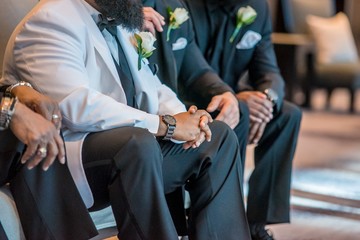 Closeup shot of the African American groomsmen sitting in the venue