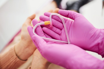 Hands in gloves holding heart shaped clinical pipes