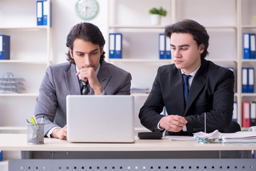 Two young employees working in the office