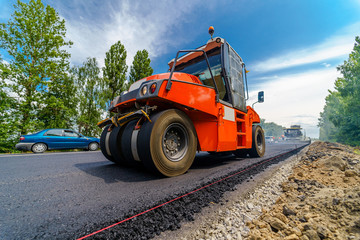 Tandem vibration roller compactor working on asphalt pavement, selective focus on road repair. © Vadim
