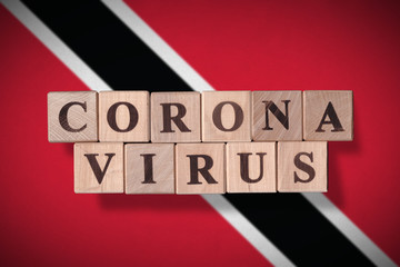 Flag of Trinidad and Tobago with wooden cubes spelling coronavirus on it. 2019 - 2020 Novel Coronavirus (2019-nCoV) concept, for an outbreak occurs in Trinidad and Tobago.