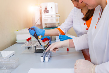 Laboratory assistants analyzing blood sample. Assistance in gloves. Prevention. Pneumonia...