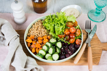 Vegan dish, quinoa salad with baked and fresh vegetables.