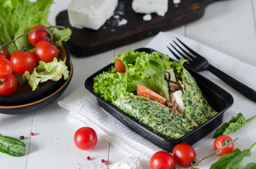 Omelet with spinach, sir feta, tomatoes and beans. Healthy food and diet concept, restaurant dish delivery. Take away of fitness meal. Weight loss nutrition in boxes.