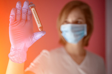 nurse wearing a mask, analyzes test tube of blood infected by coronavirus, generated in china, widespread in Italy and also arrived in the us with the risk of a 2019-ncov flu pandemic and deaths 