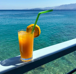 A glass of fresh orange juice with a slice of orange and a straw