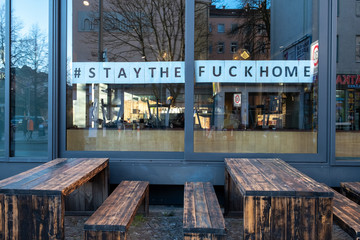 Fototapeta na wymiar #StayTheFuckHome - Aufforderung im Schaufenster des geschlossenen Restaurants Spreegold an der Schönhauser Allee/Stargader Strasse im Berliner Stadtteil Prenzlauer Berg