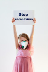 Little girl 7 years old in a medical mask shows banner ''Stop Coronavirus''. Concept 2019-nCov. Corona virus outbreaks. Epidemic virus Respiratory Syndrome. Banner for 2019 coronavirus coronavirus