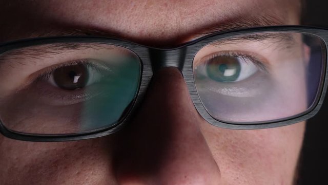 Nervous computer hacker working in the dark, closeup 