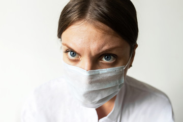 Close up of a female nurse putting on a mask to protect from airborne respiratory diseases such as...