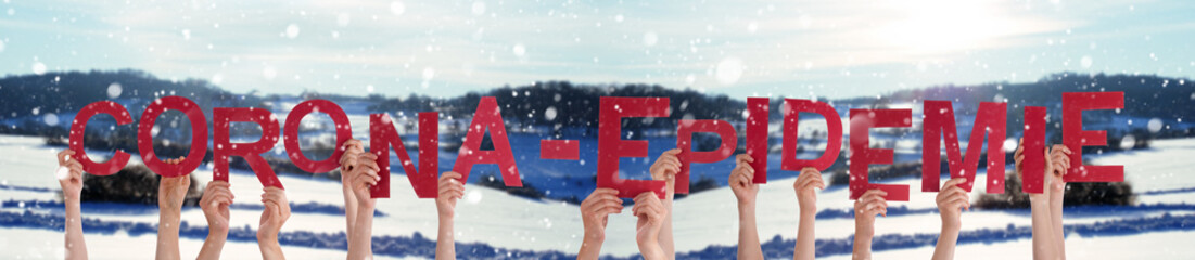 People Hands Holding Red German Corona Epidemie Means Corona Epidemic. Snowy Winter Background With...