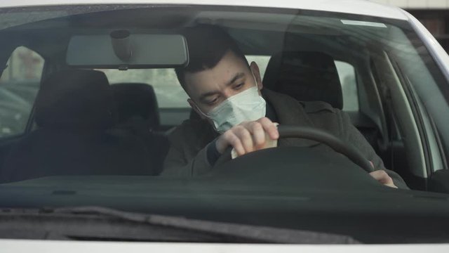 Young business man in the face mask wiping the car sharing car wheel during the pandemic coronavirus