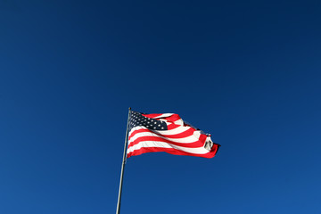 Fototapeta premium American flag waving in the wind with blue sky background