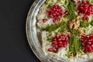 Traditional Ramadan Dessert is Gullac ready to eat on vintage metal tray on black surface with copy space