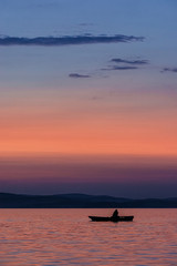 Fototapeta premium Silhouette of a boat on the water during sunset