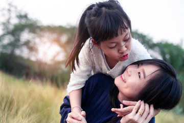 Mother and daughter hugging and lying outdoors with smillig,Concept of I love you mom