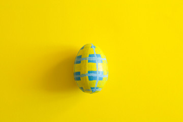 Yellow easter egg with blue pattern isolated yellow background. flat lay,overhead,top view,copy space, place for text