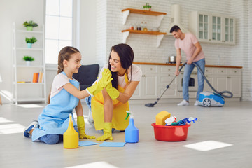 Happy family cleans the room in the house.