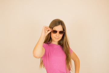 Fototapeta premium Beautiful girl with sun glasses looking into camera