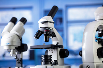 Modern scientific laboratory interior. Reaserch station with microscopes on the glass table.