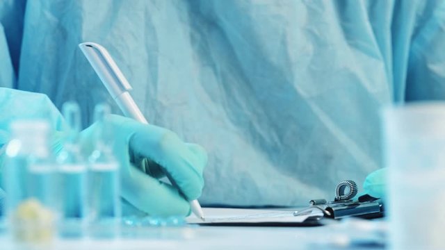 Coronavirus pandemic. Medical report. Nurse in protective equipment writing notes.