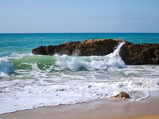 Fototapeta na wymiar Nature photo of rocks with waves in blue ocean