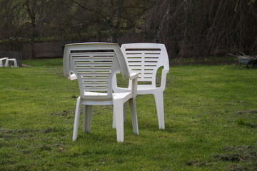 Two white plastic chairs in the garden
