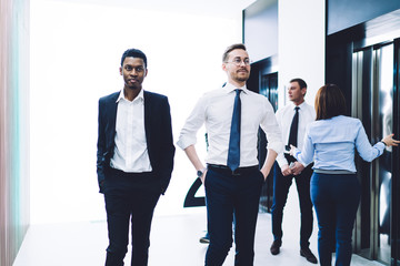 Obraz premium Multiethnic men colleagues walking down together at office hall