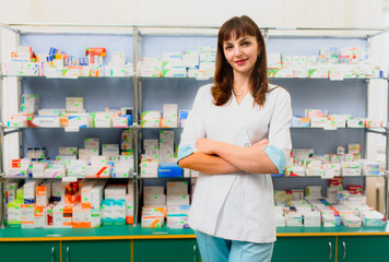 Portrait of female pharmacist standing at counter in pharmacy