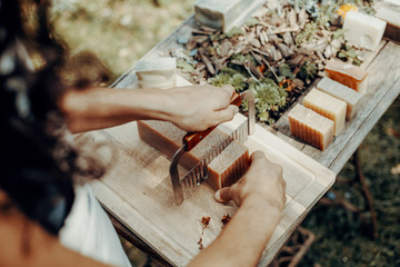 Woman is making handmade natural soaps on an old wooden table
