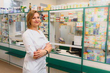 Fototapeta na wymiar Portrait of female pharmacist standing at counter in pharmacy