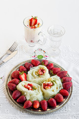 Traditional Turkish Ramadan Dessert Gullac,designed rose shape on the metal plate with fresh strawberries.Same dessert in glass.