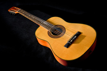 Fototapeta na wymiar Classical guitar with vibrating strings on a black background