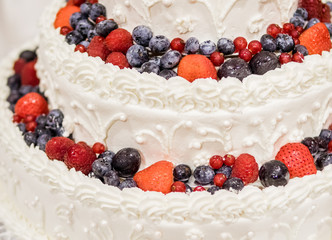 Wedding cake with white icing and blackberries strawberries