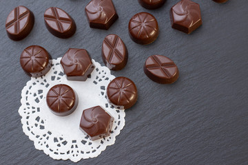 chocolate candies on a black background, cocoa powder. dark photo, mood.