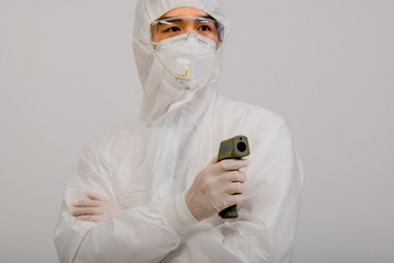 Medical team wear protective clothing And rubber gloves for fever testing by Digital Thermometer Visitor at the Information Counter to scan and protect from Coronavirus (COVID-19).