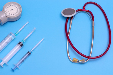 Medical stethoscope, syringes and tonometer on a blue background. Medical instruments. Place for...
