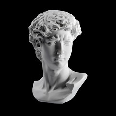 Gypsum statue of David's head. Michelangelo's David statue plaster copy isolated on black background. Ancient greek sculpture, statue of hero