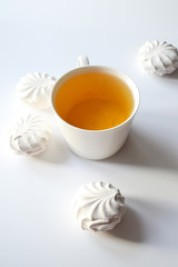 Exposition of sweet marshmallows with cup of tea on white background