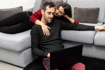Happy couple using a laptop computer in their house