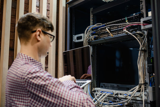 In the server room a technician/ It engineer/ hold the notebook - Powered by Adobe