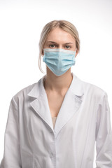 young beautiful girl with blond hair in a medical mask. On white background. Coronavirus