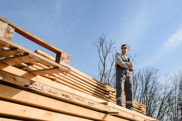man standing on the wood planks stack outside