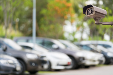 CCTV security camera on blur car parking background.