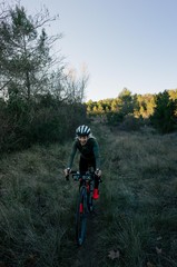 Obraz na płótnie Canvas Female cyclist ride sunset in forest